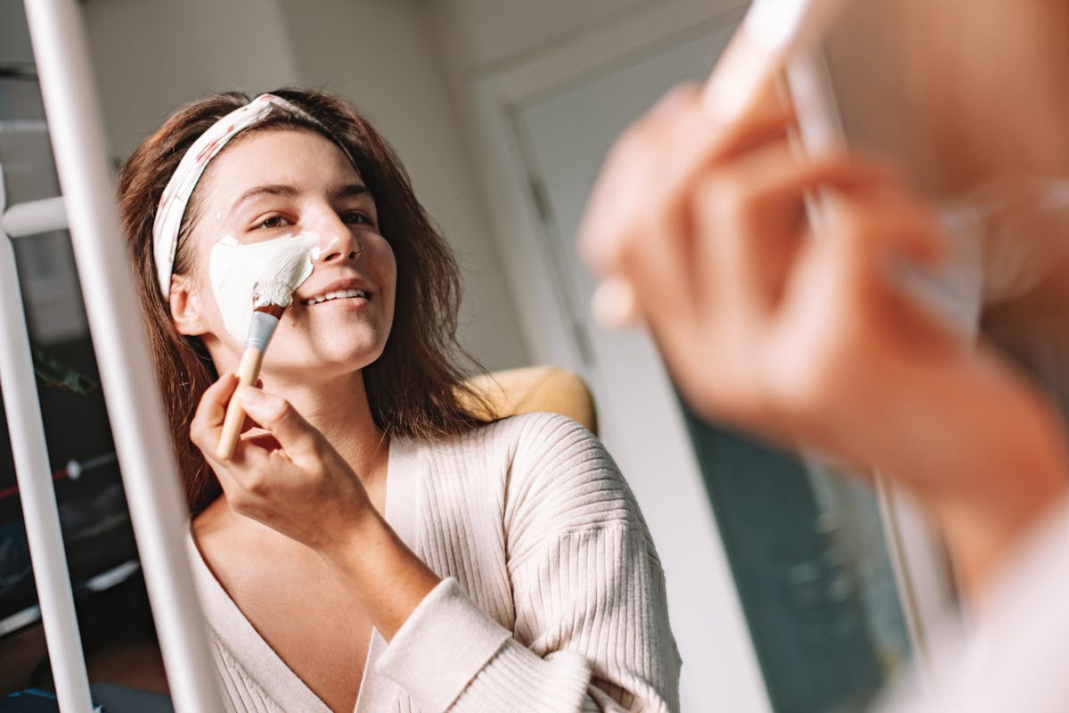 Kvinde påfører ansigtsmaske foran spejl – microneedling nybegynder guide – Trondahl Skincare