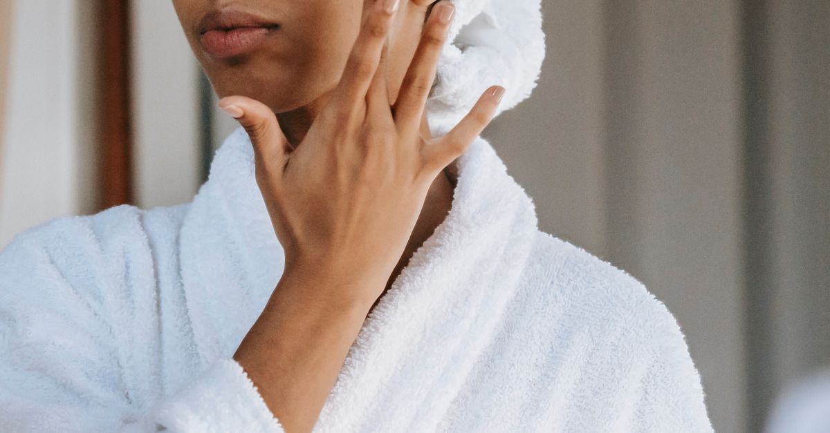 Kvinde smører fugtcreme på ansigtet i badeværelset – Phytosphingosine i hudpleje – Trondahl Skincare