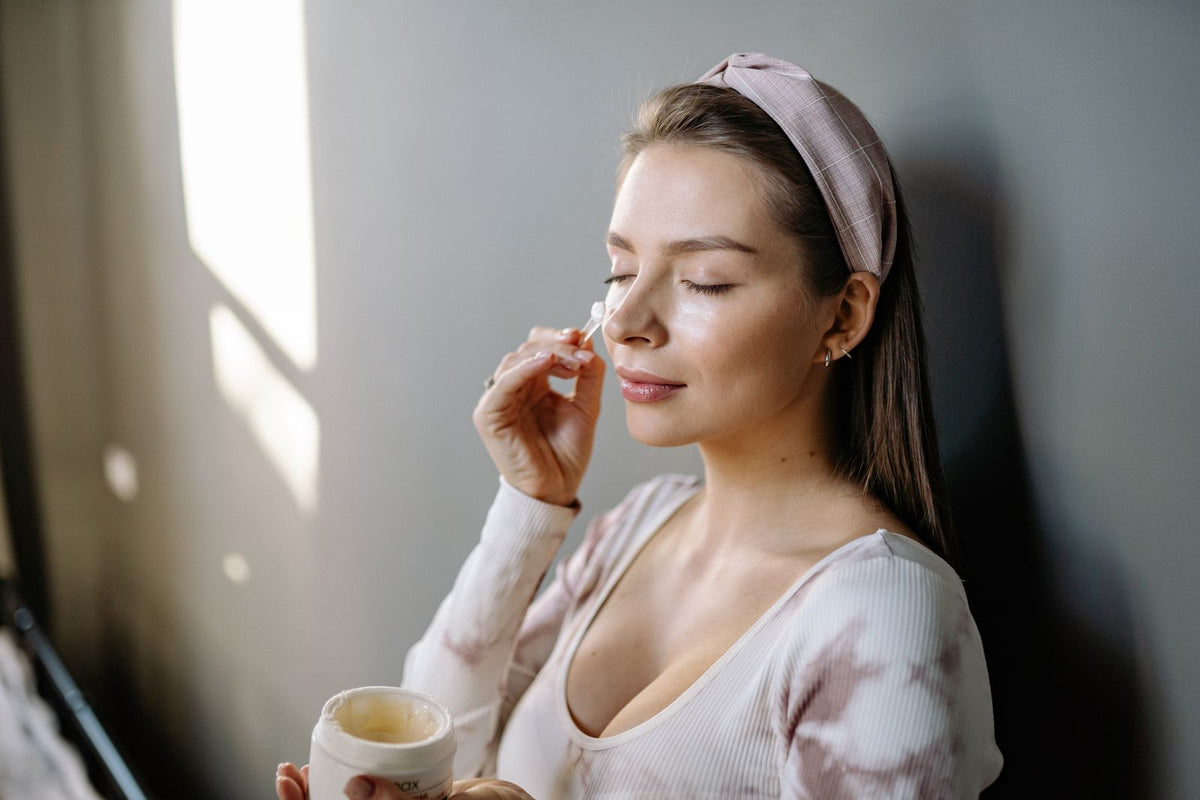 Kvinde smører creme på ansigtet – øjencreme og ingredienser – Trondahl Skincare