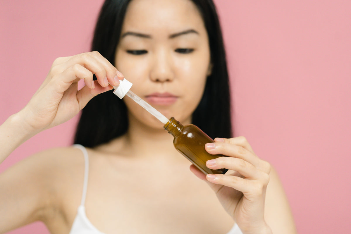 Kvinde holder serum med pipette – Adenosin – Trondahl Skincare