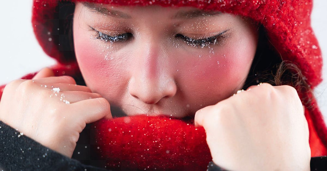 Kvinde i koldt vintervejr med rød hue – hudpleje om vinteren guide – Trondahl Skincare