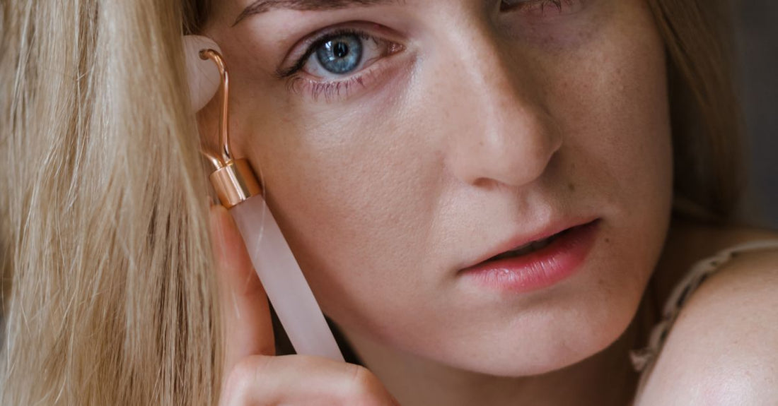 Kvinde bruger ansigtsroller på hals og kæbelinje – microneedling hals og décolleté – Trondahl Skincare