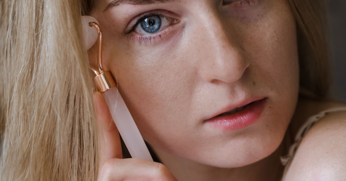 Kvinde bruger ansigtsroller på hals og kæbelinje – microneedling hals og décolleté – Trondahl Skincare