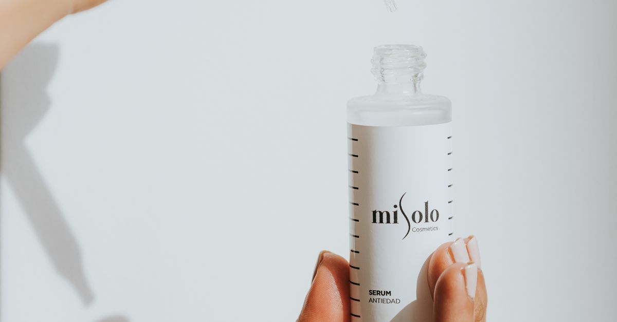 Hånd holder serum-dråbetæller mod hvid baggrund – Ectoin – Trondahl Skincare