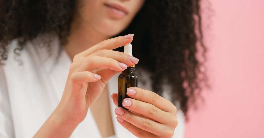 Kvinde holder serum dropperflaske – retinol guide til begyndere – Trondahl Skincare